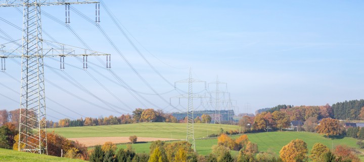 Das freundliche Foto im Querformat zeigt eine Trasse in hügeliger und grüner Landschaft unter einem blauen Himmel.